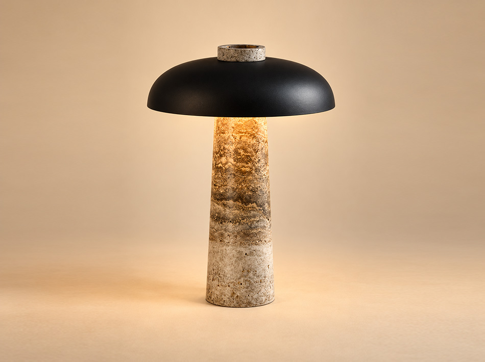 Dover matte black dome table lamp with cylindrical grey Silver Travertine stone base and warm illumination highlighting the natural stone texture.