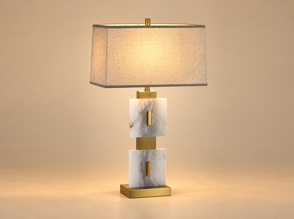 Capital brushed gold table lamp with two rectangular white alabaster panels featuring grey veining, a geometric metal base and light brown linen shade.